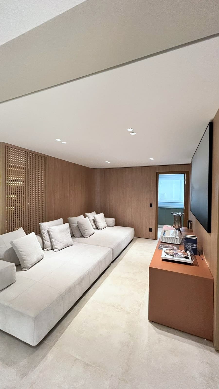 Sala de estar com TV e marcenaria em madeira do piso ao teto