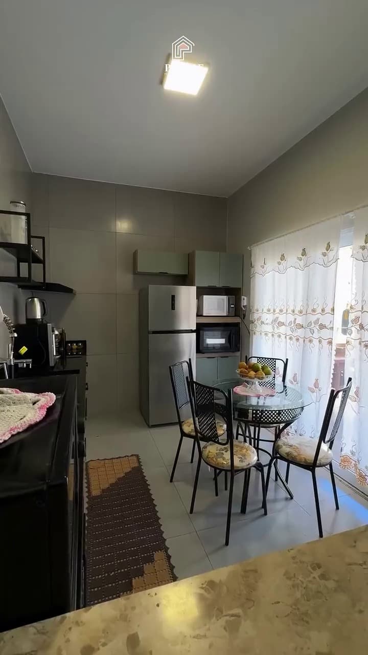 Cozinha planejada com bancada escura, integrada à copa