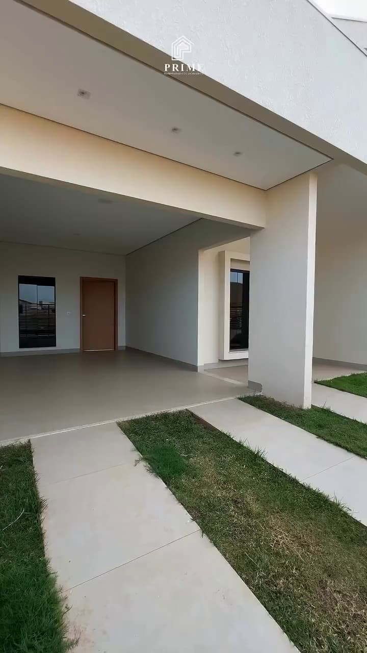 Garagem coberta e entrada com faixas de grama entre as pistas de concreto